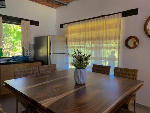une cuisine avec une table en bois et un vase de fleurs. dans l'établissement Cabañas Rinconada Tapalpa, à San Antonio