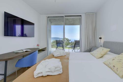 a hotel room with a bed and a desk and a television at Villa Diamante del Garda & Spa in Toscolano Maderno