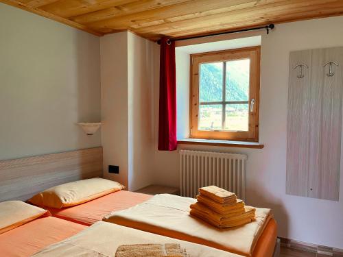 two beds in a room with a window at Chalet I Clus in Livigno