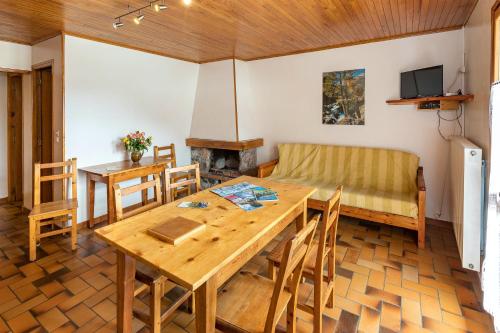 uma sala de estar com uma mesa de madeira e um sofá em Appartement de 2 chambres avec balcon et wifi a Le Coin em Arvieux