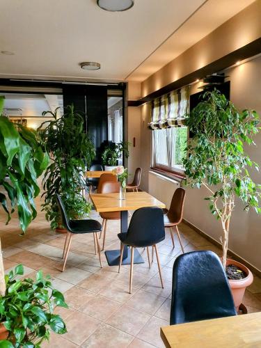 a room with tables and chairs and potted plants at MDS Wielichowo in Wielichowo