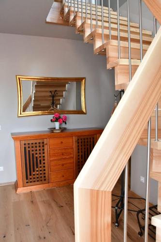 a staircase with a mirror and a wooden dresser at Domizil Eutschützgrün in Bannewitz