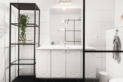 La salle de bains blanche est pourvue d'un lavabo et d'une douche. dans l'établissement Villa i Bjørnafjorden, à Osøyro