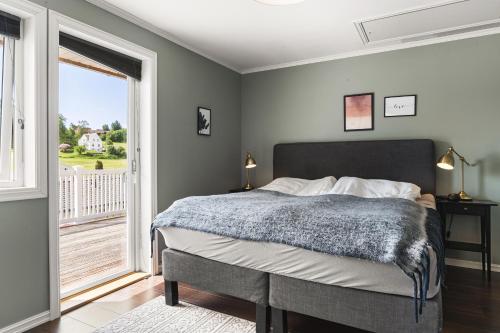 a bedroom with a bed and a large window at Villa i Bjørnafjorden in Osøyro