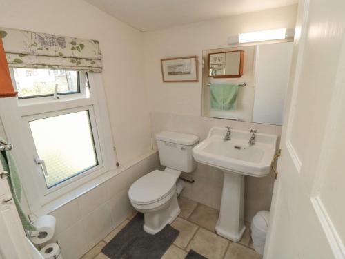 a white bathroom with a toilet and a sink at Damson Croft in York