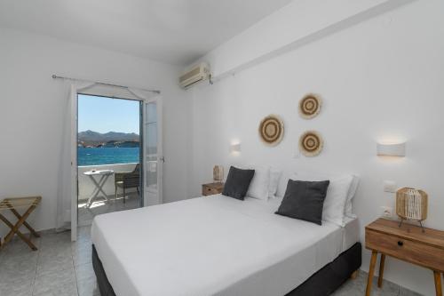 a bedroom with a white bed and a view of the ocean at ILIAS SEA VIEW in Pollonia