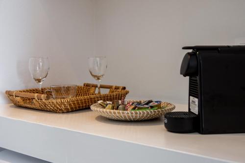 dos cestas y copas de vino en un mostrador junto a un microondas en ILIAS SEA VIEW, en Pollonia