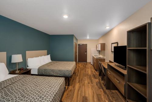 Habitación de hotel con 2 camas y TV de pantalla plana. en WoodSpring Suites West Palm Beach en West Palm Beach