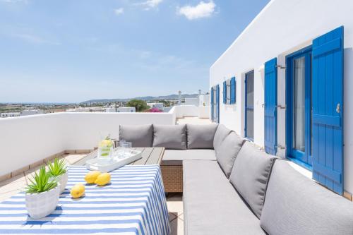 a patio with a couch and a table on a balcony at Sealit Deluxe Apartment in Drios