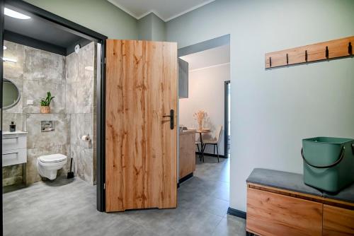 łazienka z toaletą i drewnianymi drzwiami w obiekcie Apartment 93B w Nowej Soli