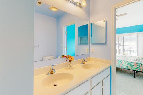 a bathroom with two sinks and a mirror at Rehoboth Crossing --- 19913 Ames Drive #106 in Rehoboth Beach