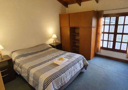 1 dormitorio con 1 cama y 2 mesas con lámparas en JM Casa Hermosa en Ushuaia