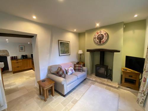 a living room with a couch and a fireplace at Characterful, Cosy Cotswold Cottage, Folly Cottage in Avening