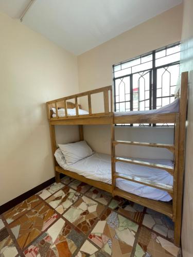 two bunk beds in a room with a window at Maria Kulafu Lodging House Pier site- Santa Clara office 2nd Floor 