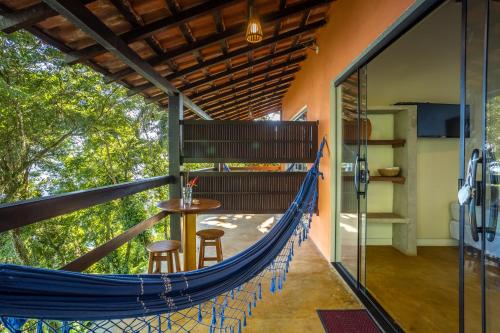 a hammock on the side of a house at Pousada Lagamar in Praia Vermelha