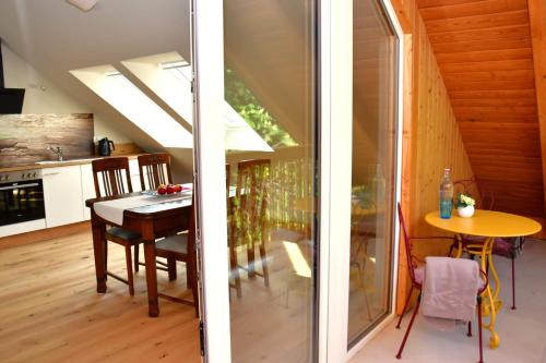 a kitchen and dining room with a dining table and a room with a window at Domizil Eutschützgrün in Bannewitz
