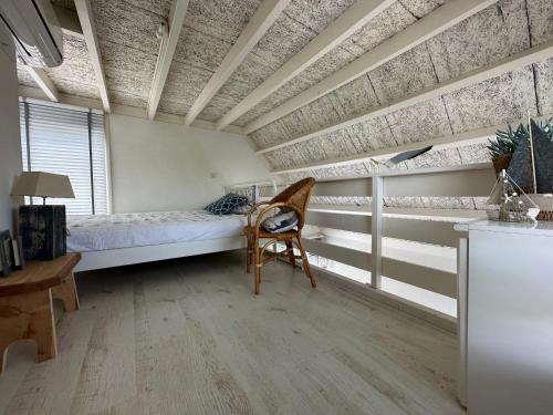 1 dormitorio con cama, escritorio y silla en Vakantiebungalow Mee naar Ouddorp aan zee, en Ouddorp
