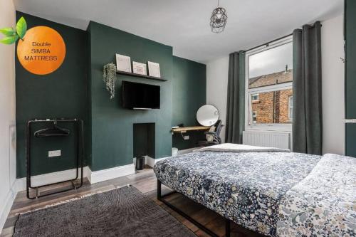 ein Schlafzimmer mit einem Bett und einer grünen Wand in der Unterkunft Orange Rentals-Characteristic Victorian terrace 5 bedroom house in Liverpool