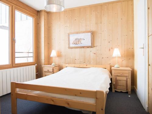 - une chambre avec des murs en bois et un lit avec des draps blancs dans l'établissement 3 pièces au pied des pistes, exposé sud, 65m², 3 chambres - FR-1-449-6, à Tignes
