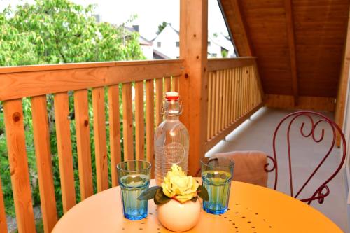a table with two glasses and a bottle on a balcony at Domizil Eutschützgrün in Bannewitz