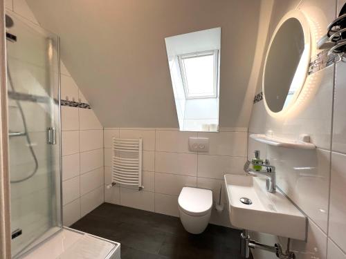 een badkamer met een toilet, een wastafel en een douche bij Pension Seepferdchen in Norddeich