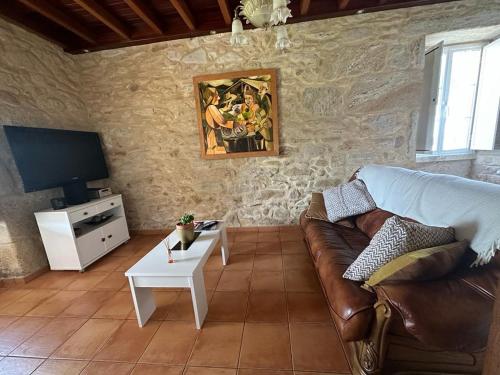 sala de estar con sofá y TV en Casa de Romaxe, en Muros