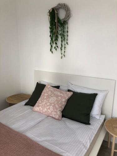 1 cama con almohadas blancas y negras y zona de estar en la pared en Apartament Skandynawski, en Chojnice