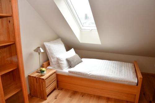 a small bedroom with a bed with a skylight at Domizil Eutschützgrün in Bannewitz