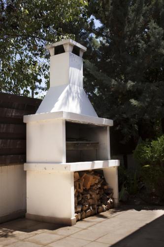 a white building with a pile of fire wood at El Marco Villa in Pissouri