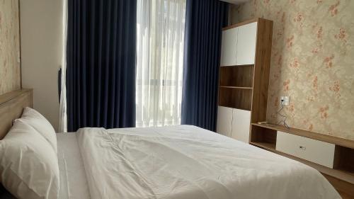 a bedroom with a white bed and a window at Kim House Apartment Da Nang in Danang