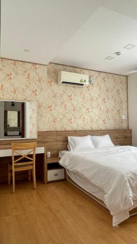 a bedroom with a bed and a desk with a mirror at Kim House Apartment Da Nang in Danang
