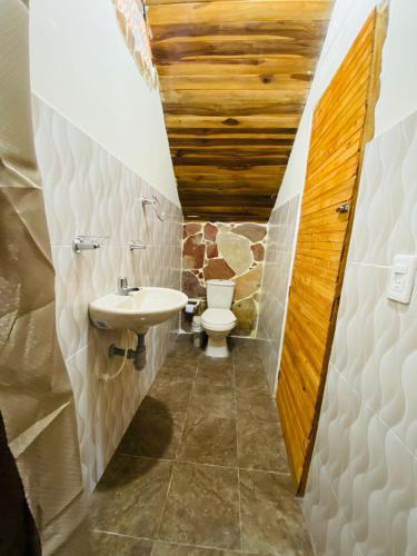 a bathroom with a toilet and a sink at CABAÑAS EL PARAISO PESCADERITO in Curití