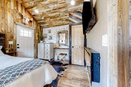 a bedroom with a bed in a room with wooden walls at The Montclair Drive Delight in Kalispell