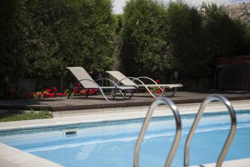 two chairs sitting next to a swimming pool at El Marco Villa in Pissouri