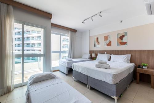 巴西利亚BSB STAY Premium Flats Particulares - Saint Moritz的一间有两张床和一扇大窗户的卧室