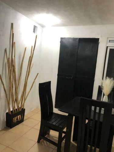 a dining room with a black table and two chairs at lindo departamento independiente in Taxco de Alarcón