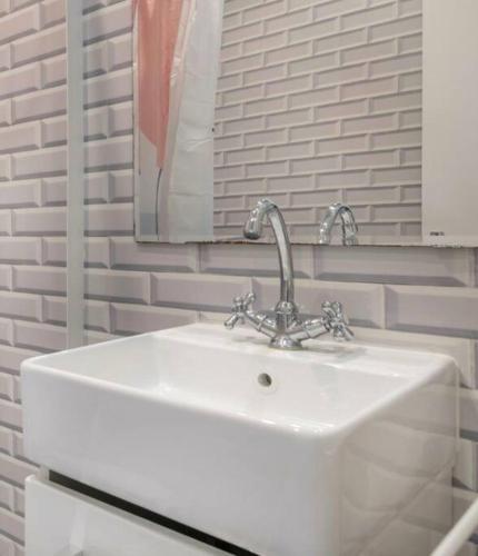 un lavabo blanc dans une salle de bain avec un miroir dans l'établissement Appartement de ville, à Nantes