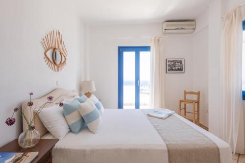 Dormitorio blanco con cama y vistas al océano en Sealit Deluxe Apartment, en Drios