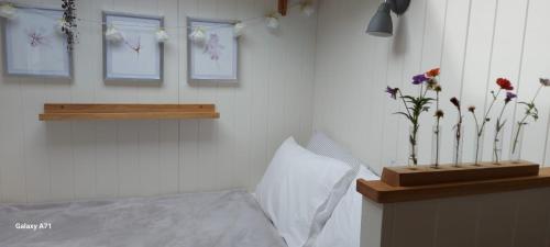 sypialnia z łóżkiem i kwiatami na ścianie w obiekcie The Holcombe Hut, Ridgefield House w mieście Longdown