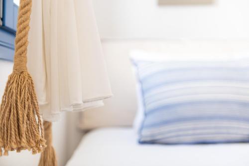 a close up of a bed with a curtain and a pillow at Sealit Deluxe Apartment in Drios