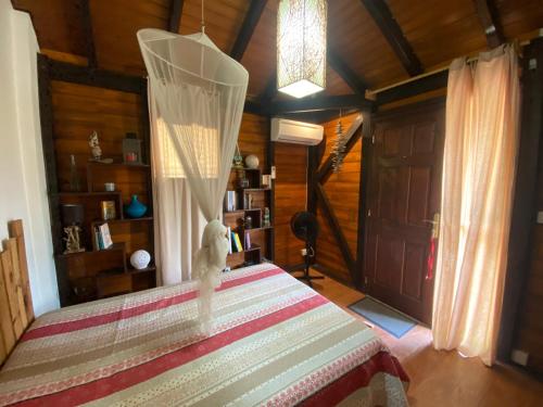a bedroom with a bed with a curtain on it at La Baie du Bonheur in Deshaies