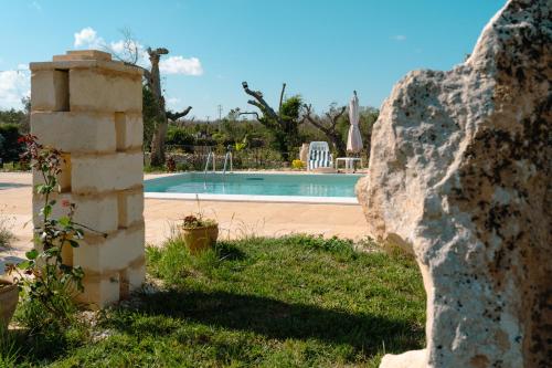 a stone wall next to a swimming pool at Tenuta San Lorenzo in Otranto