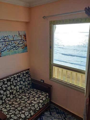 a small room with a couch next to a window at Panorama Apartment with a charming sea view near Alexandria and Burg ElArab Airport with Free Wifi شقة باطلالة ساحرة على البحر اول الساحل الشمالي واي فاي مجاني迷人海景公寓 免费无线网络 in Alexandria