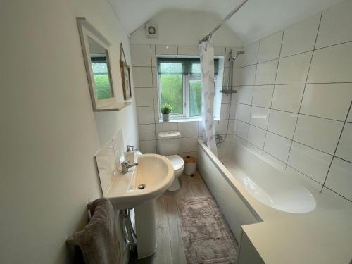 y baño con lavabo, bañera y aseo. en Tucked away house in Macclesfield, en Macclesfield