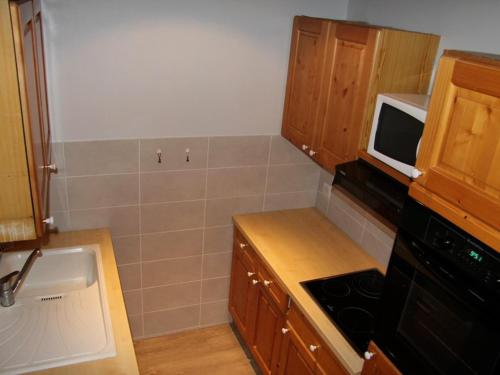 une petite cuisine avec un évier et un micro-ondes dans l'établissement 3 pièces centre La Clusaz proche piscine, 6-7 pers - FR-1-459-26, à La Clusaz