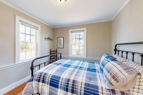 um quarto com uma cama e duas janelas em The Eagle's Hill em Plymouth