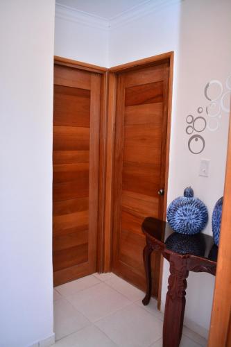 a hallway with a wooden door and a table with vases on it at Moderno apartamento para tu estancia in Licey