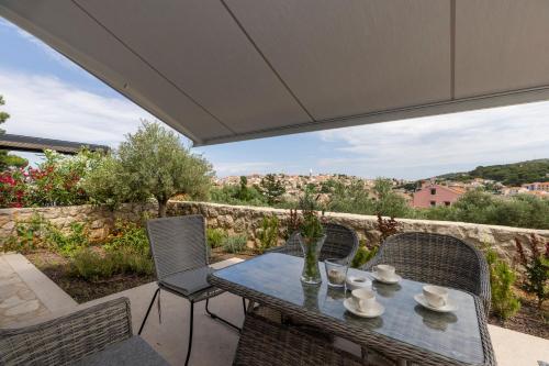 a table and chairs on a patio with a view at Apartments Tony in Mali Lošinj