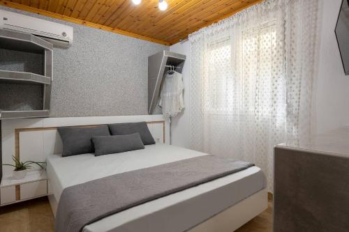 a small bedroom with a bed and a window at ViLLA DRAGANI in Sikia