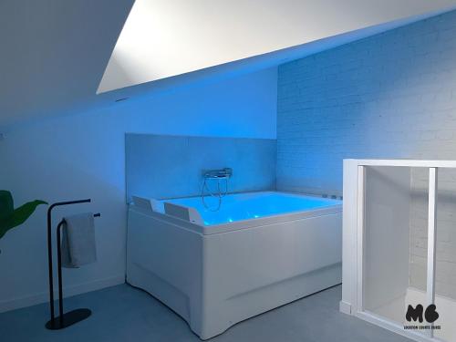 a bathroom with a bath tub with a blue light at Maison Brigitte - Jacuzzi Videoprojecteur Xbox in Aulnoy